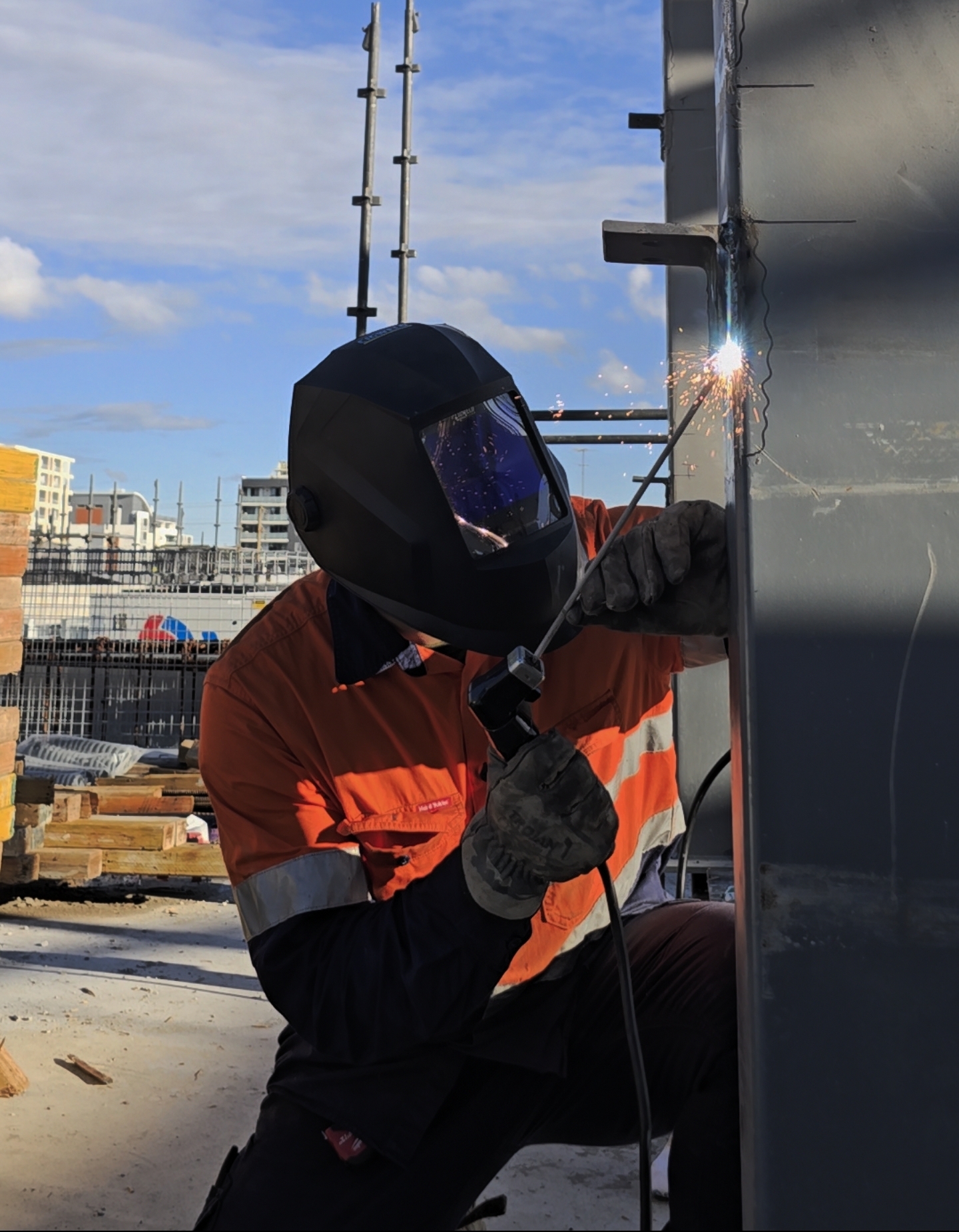 Welder completing a structural steel connection on site